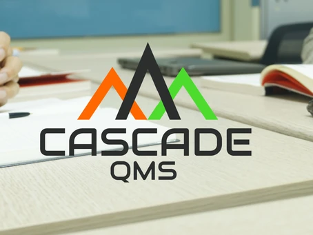 Handbooks on a table with Cascade QMS logo