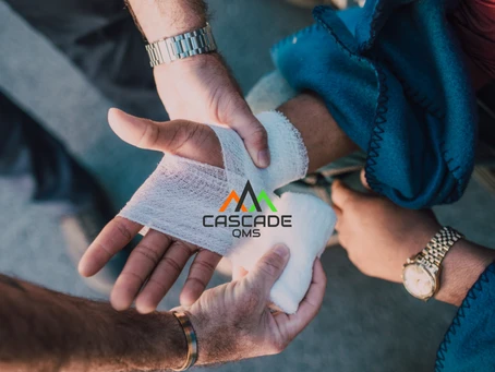 Worker hand being bandaged with gauze and Cascade QMS logo on image.