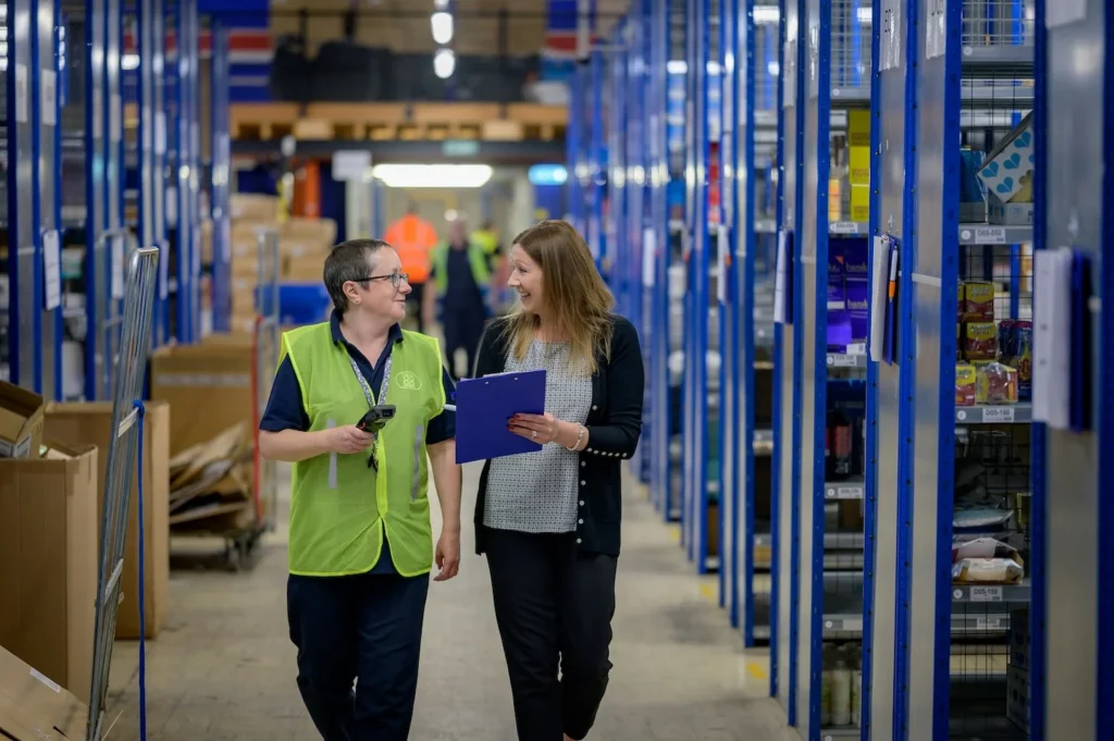 Warehouse manager and warehouse employee walking.