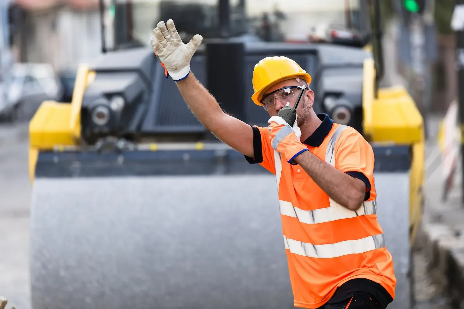 Construction worker directing traffic using walkie talkie.
