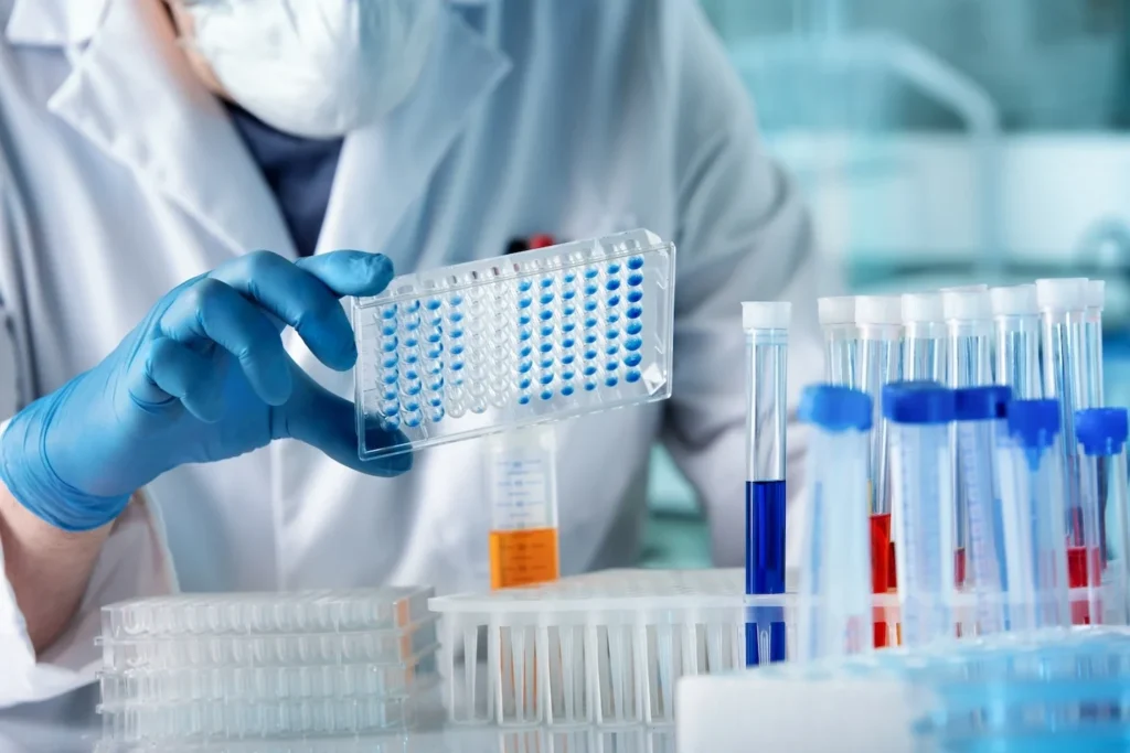 Pharmaceutical researcher working with panel microplates in a laboratory.