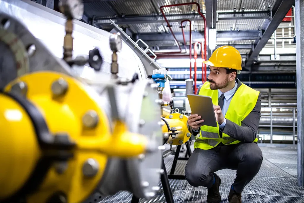 Person working in industrial building checking equipment for safety standards.
