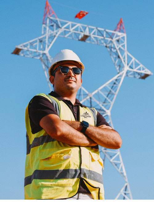 Utility safety manager wearting hard had and vest under utility line with cascade qms logo on vest
